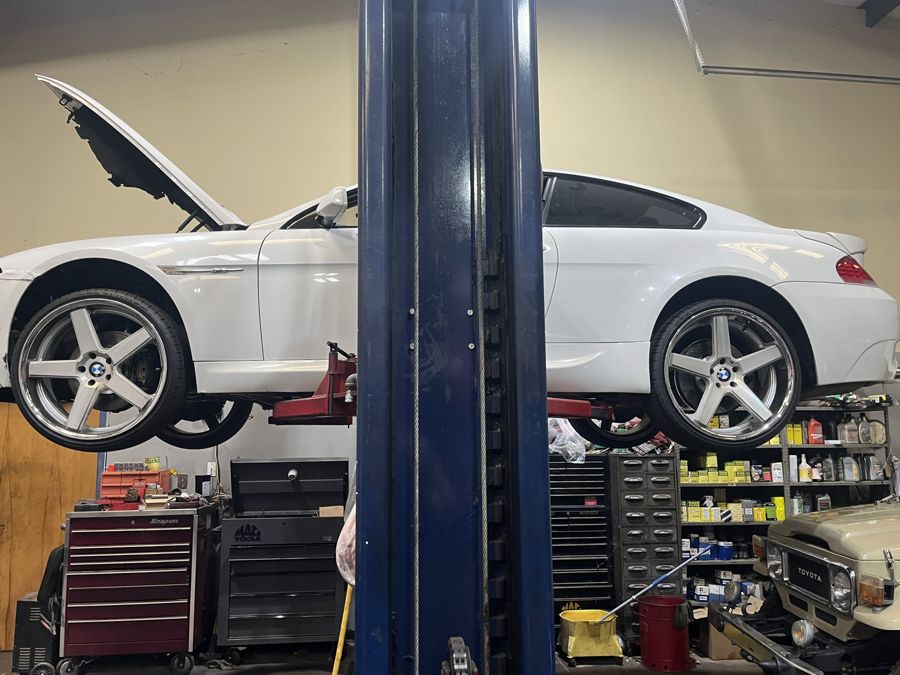 White BMW 6 Series coupe on a lift at Athens Import Auto Repair