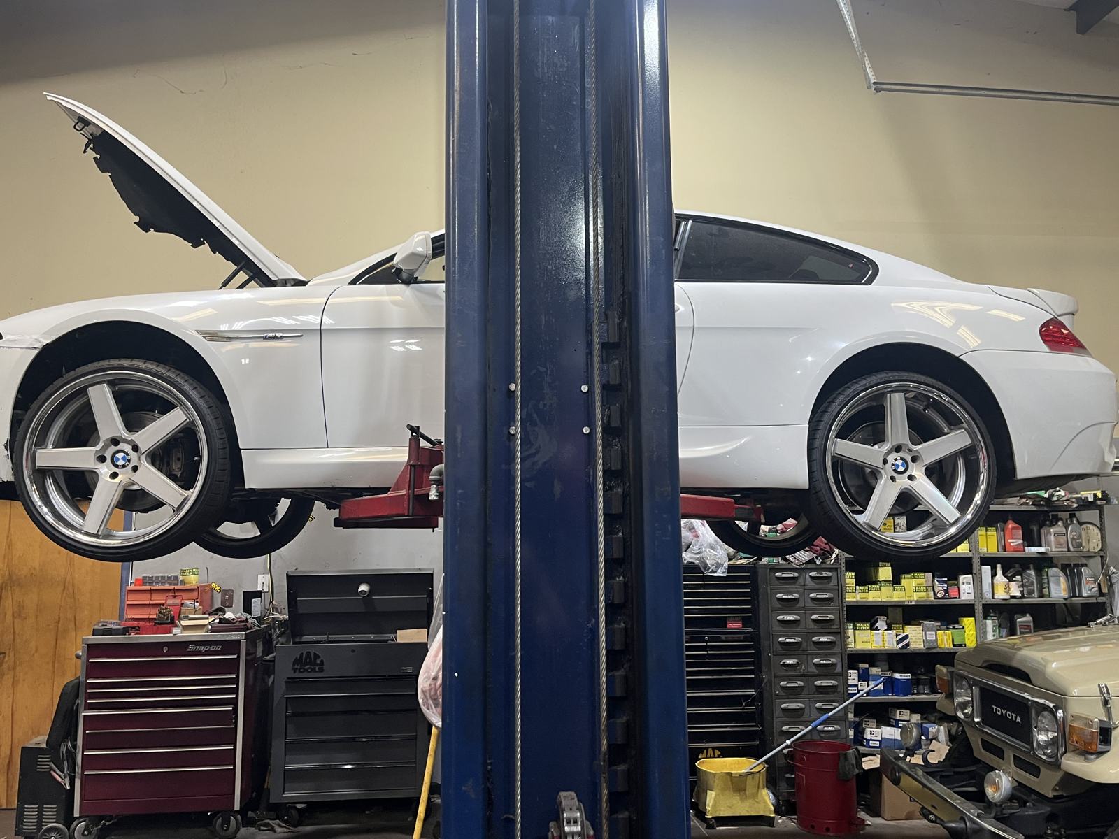 White BMW 6 Series coupe on a lift at Athens Import Auto Repair